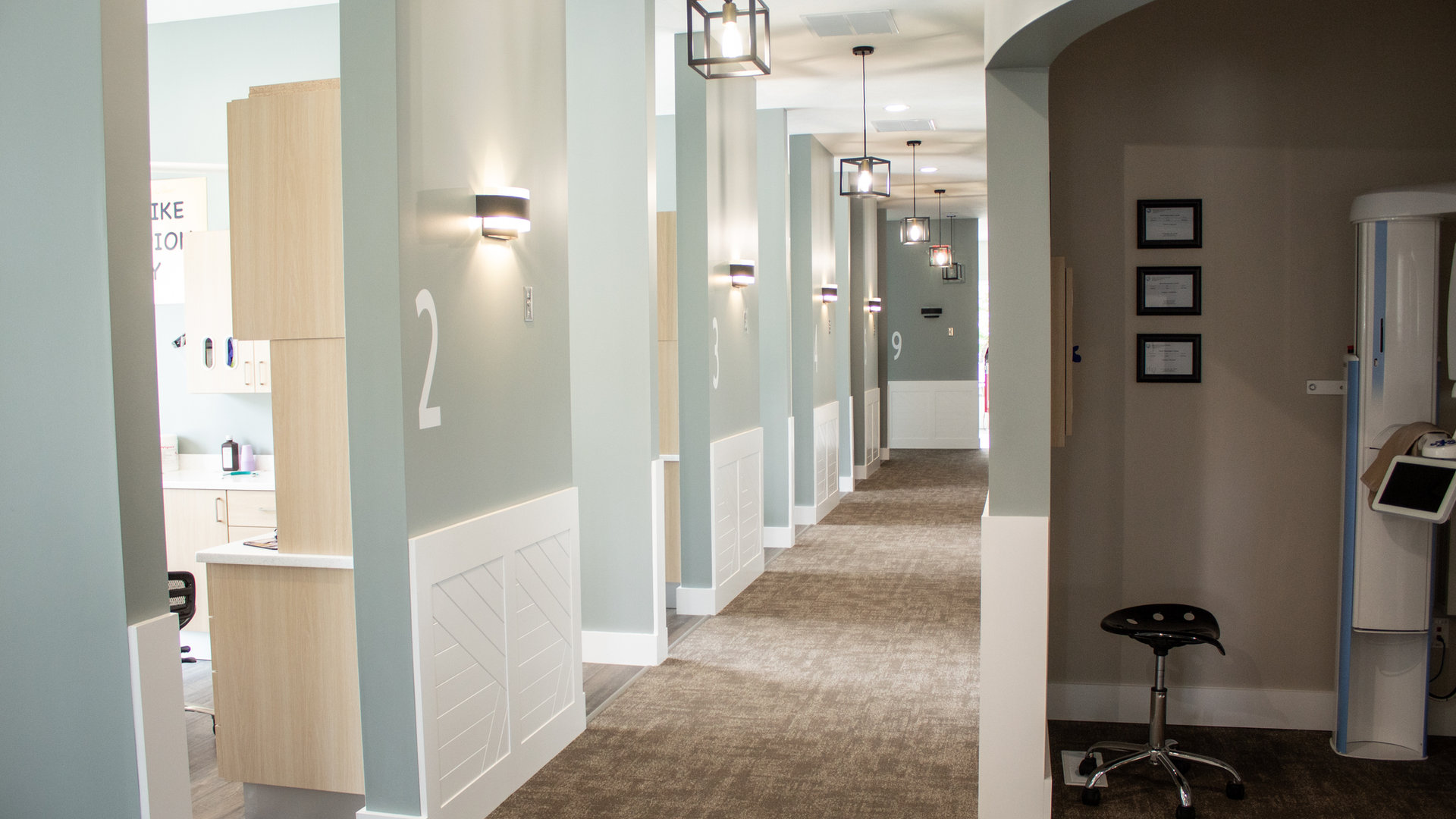A hallway of numbered treatment rooms
