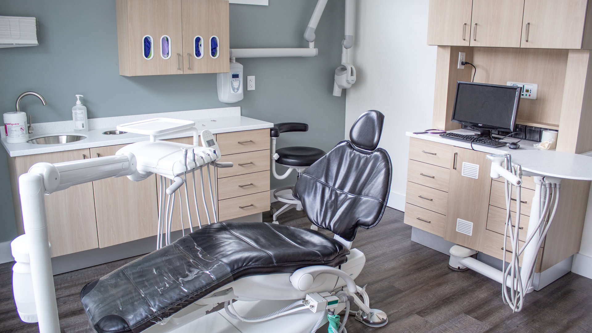 A treatment room with a dental chair and modern equipment
